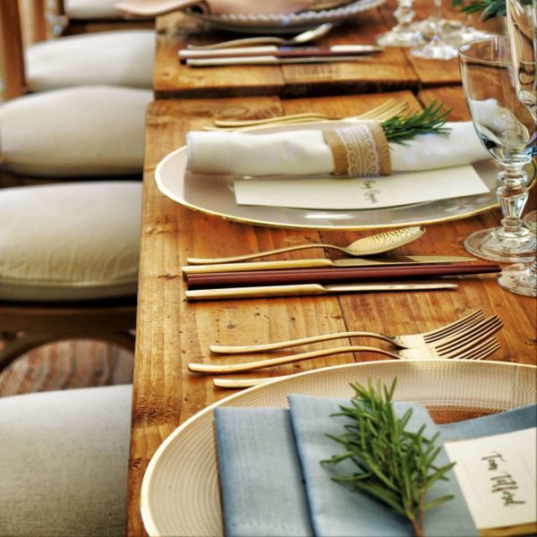 Image: silverware and plates set up for fine dining.